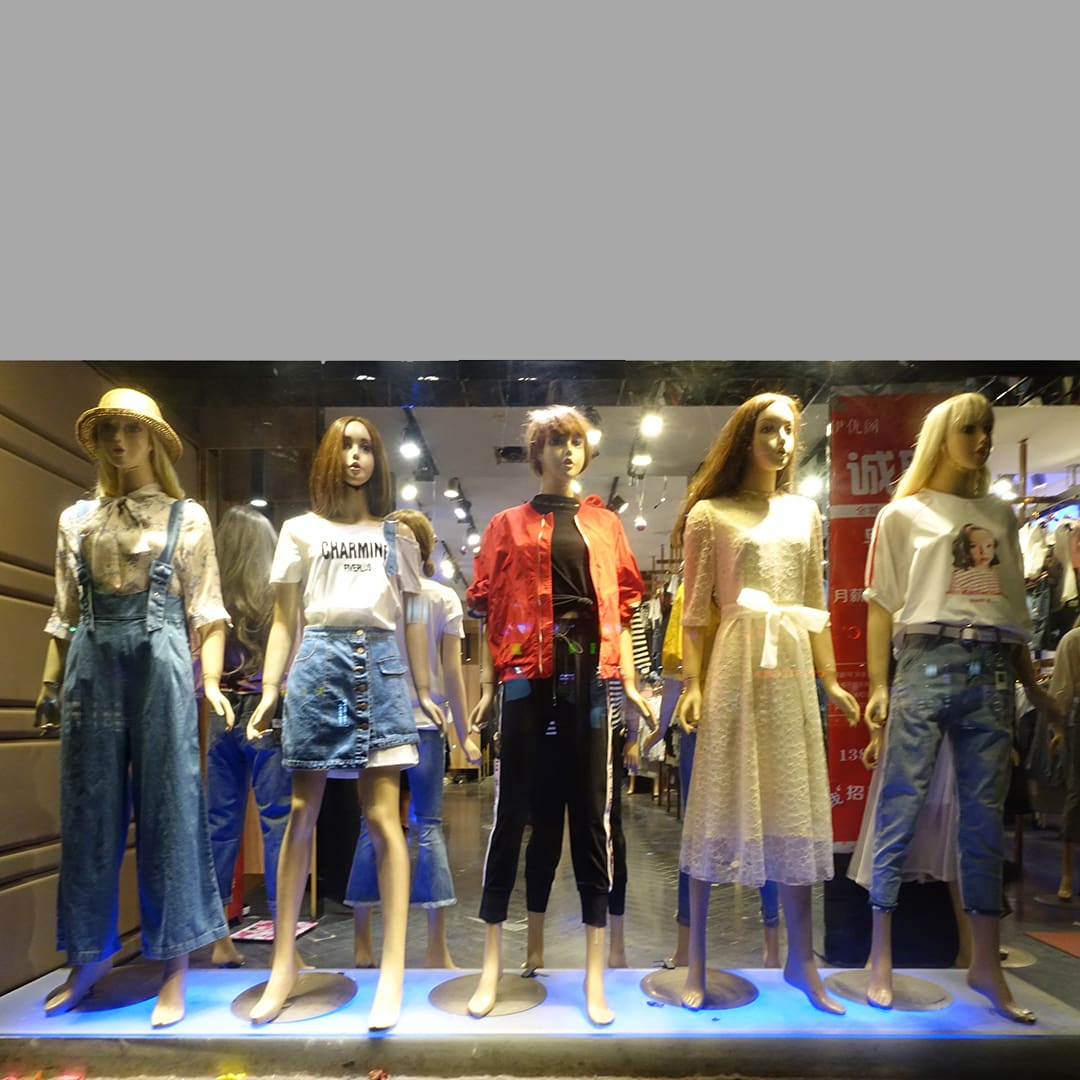 Five mannequins with clothes on display