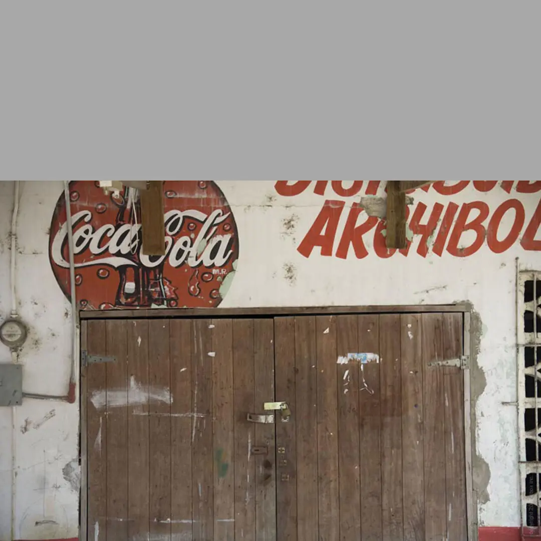 Coca cola print on the wall with cupboard below